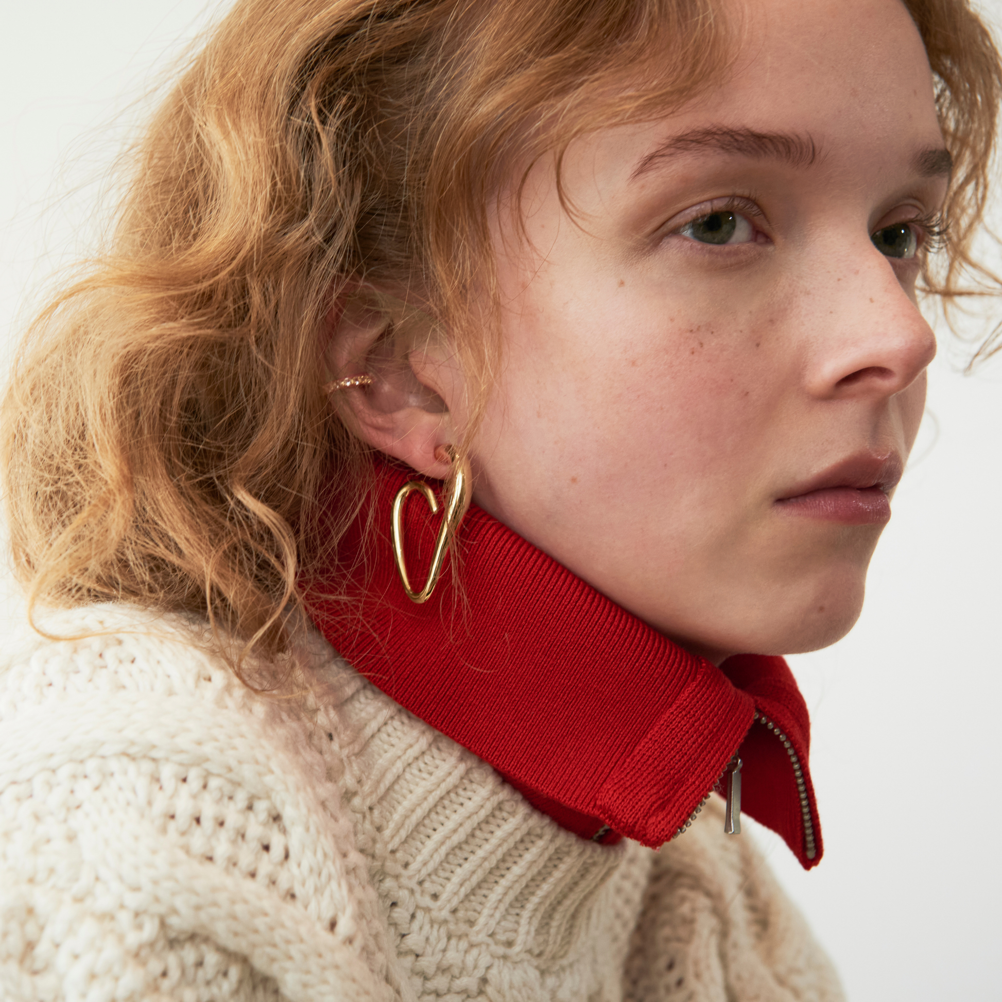 close up of model wearing the abstract heart hoop earrings and ear cuff