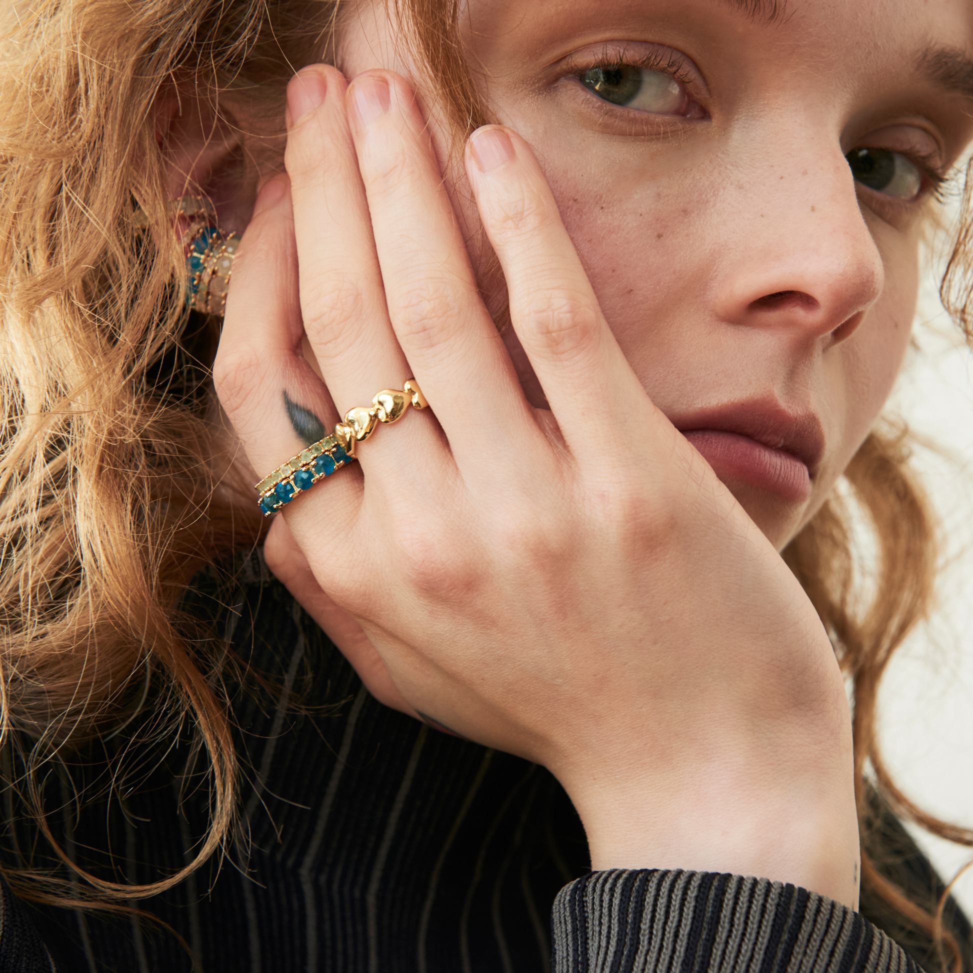 model wearing eternity band rings including the 4mm apatite eternity band ring along with the endless hearts ring