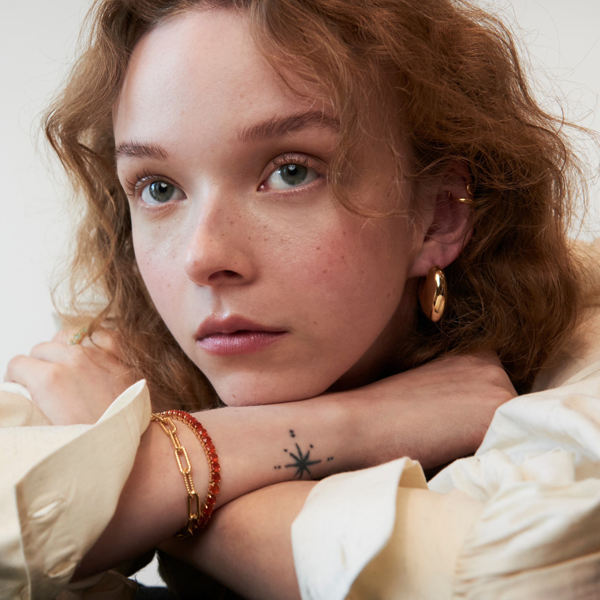 model wearing gold jewellery including the paperclip link bracelet