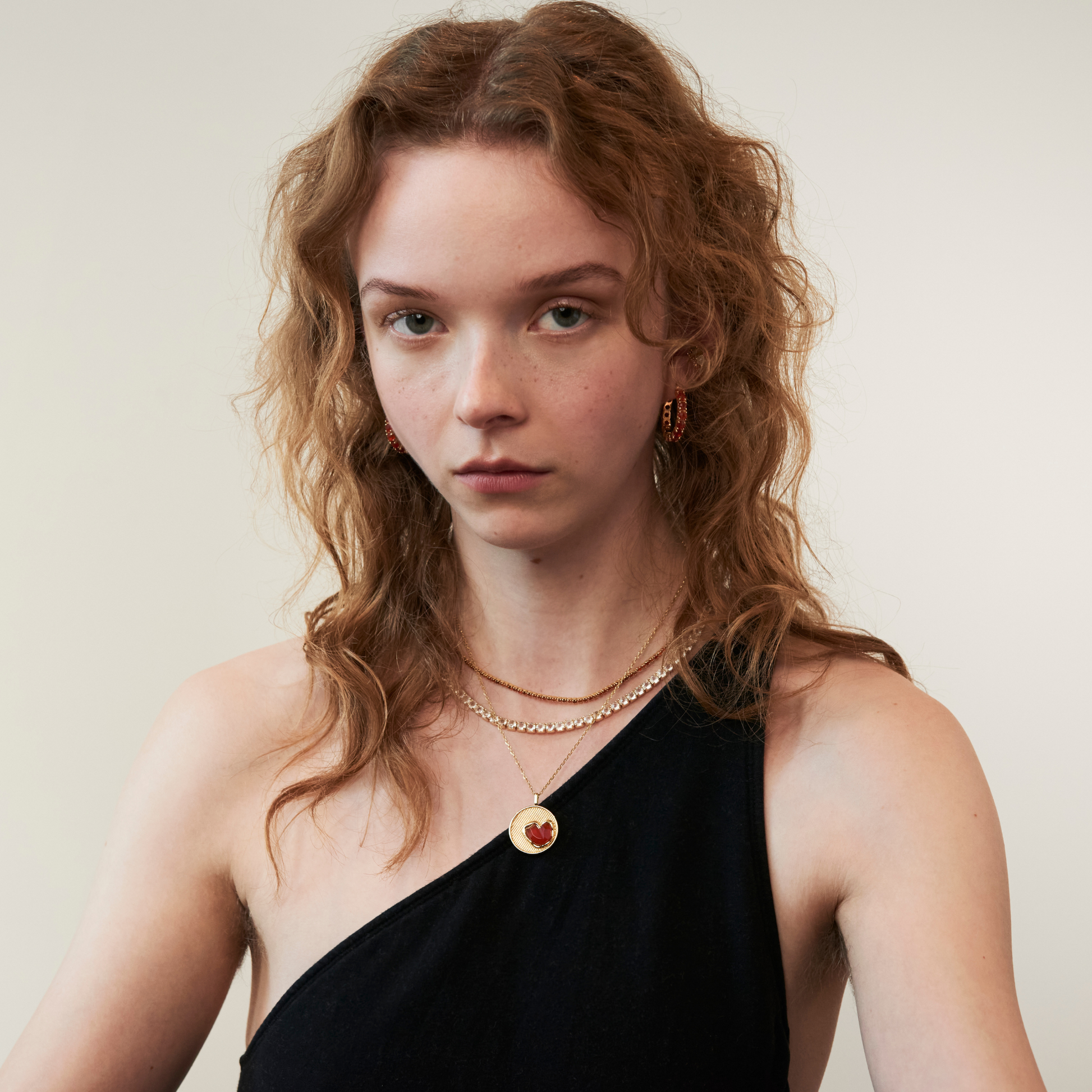 model wearing layered gemstone gold necklaces including the 2mm carnelian tennis necklace