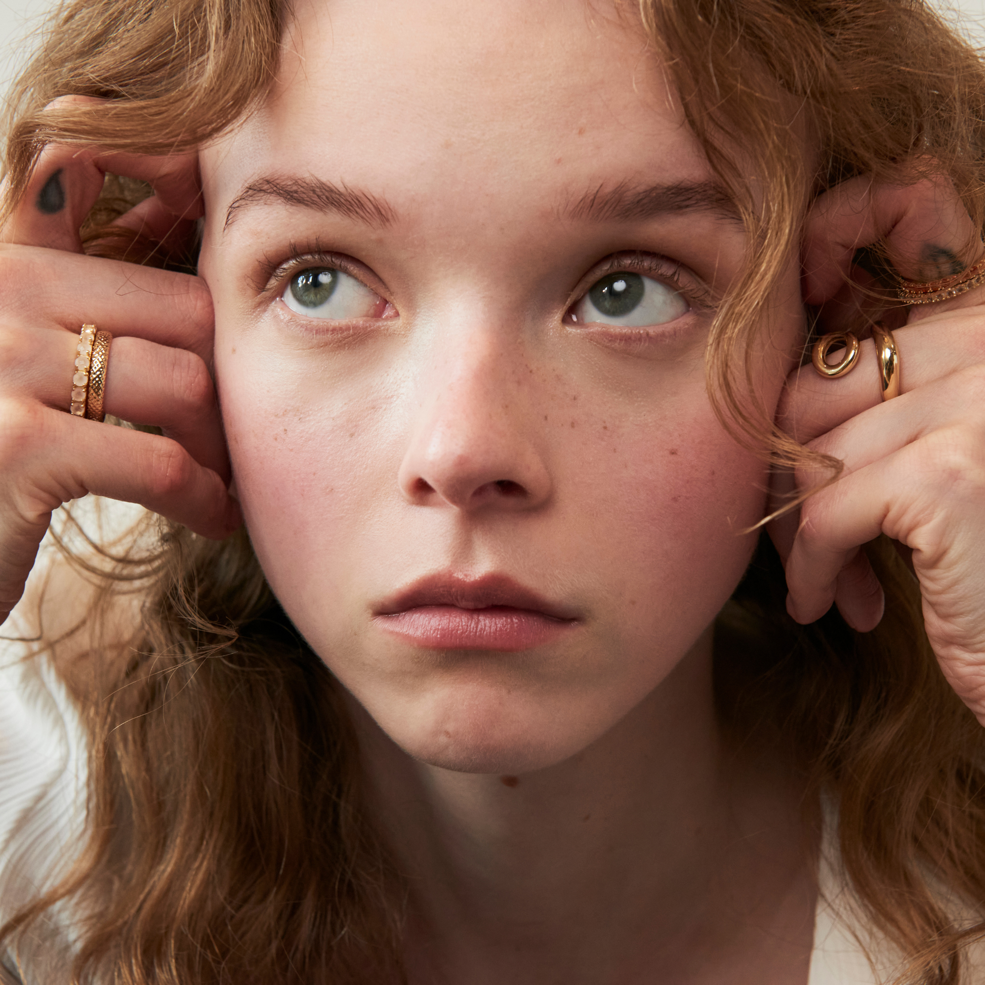 model wearing the 3mm rose quartz eternity band ring and the abstract heart ring