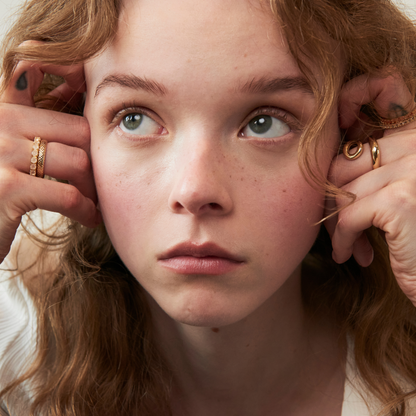 model wearing the 3mm rose quartz eternity band ring and the abstract heart ring
