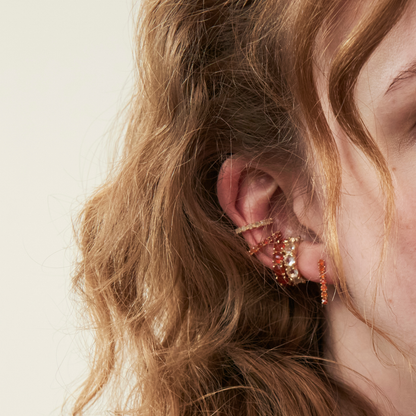 model wearing gold ear stack including the carnelian mini tennis earrings and ear cuffs