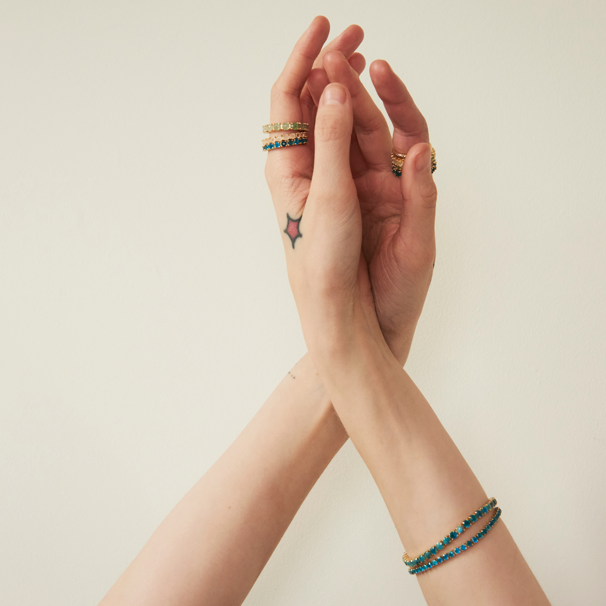 model wearing gold jewellery including the 4mm apatite tennis bracelet
