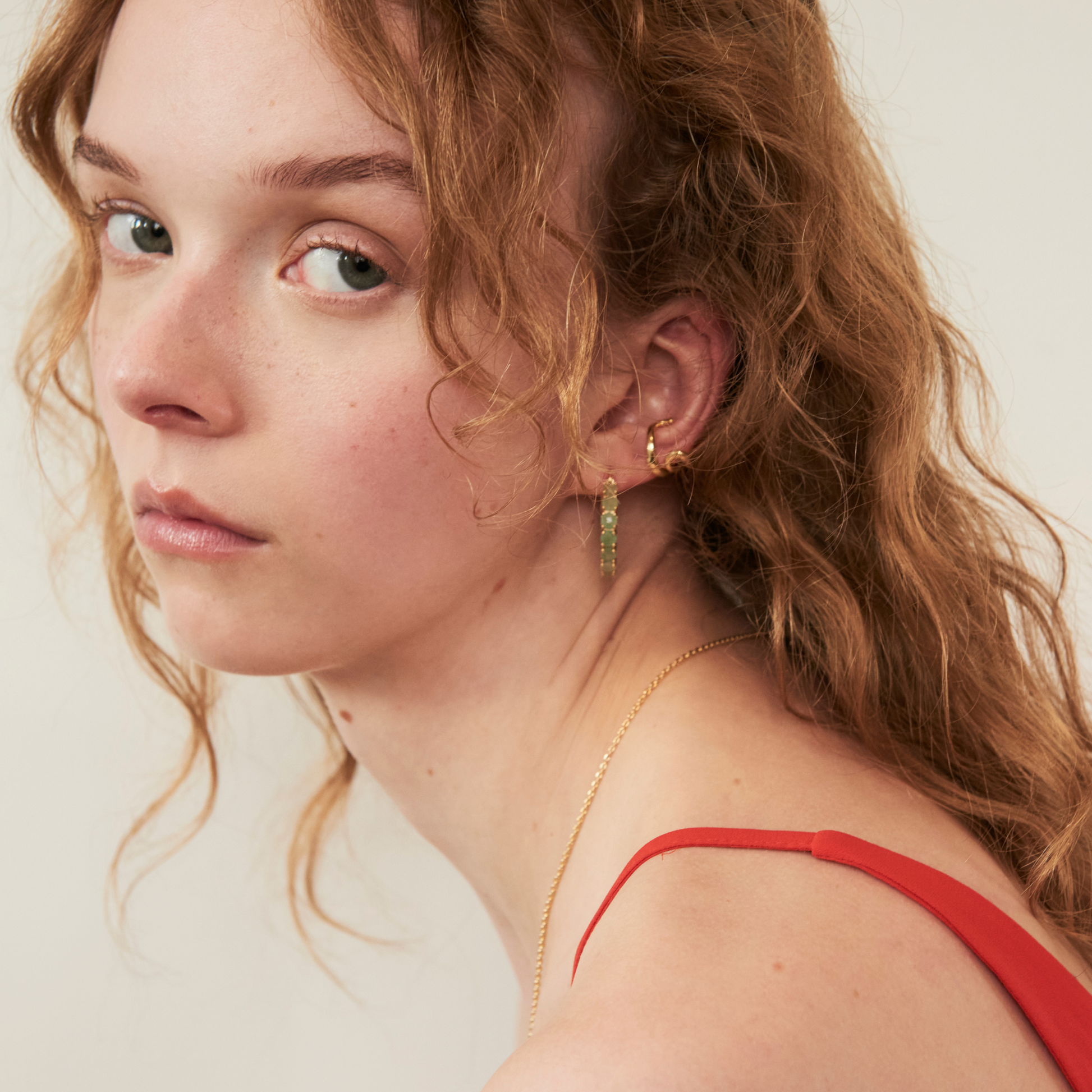 model wearing the 25mm aventurine hoop earrings aloong with the abstract heart ear cuff