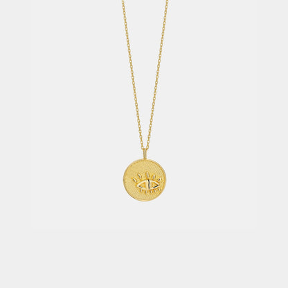 Gold necklace with a round pendant on a light gray background
