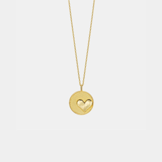 Gold necklace with a heart-shaped pendant on a light gray background