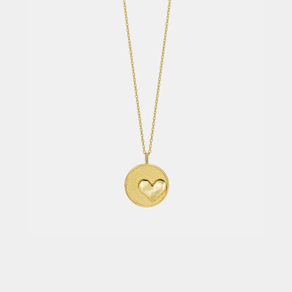 Gold necklace with a heart-shaped pendant on a light gray background