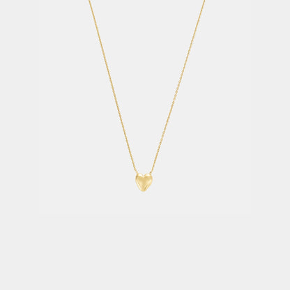 Gold heart-shaped pendant necklace on a light gray background